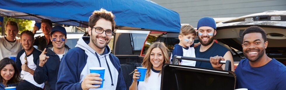 Happy group of friends grilling at a high school football game tailgate_L